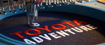Embroidery machine stitching Toyota Adventure logo